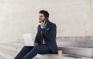 Homme au téléphone assis avec un ordinateur ( micro entrepreneur)